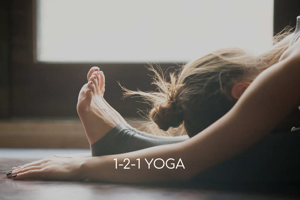 A woman in seated forward bend yoga pose